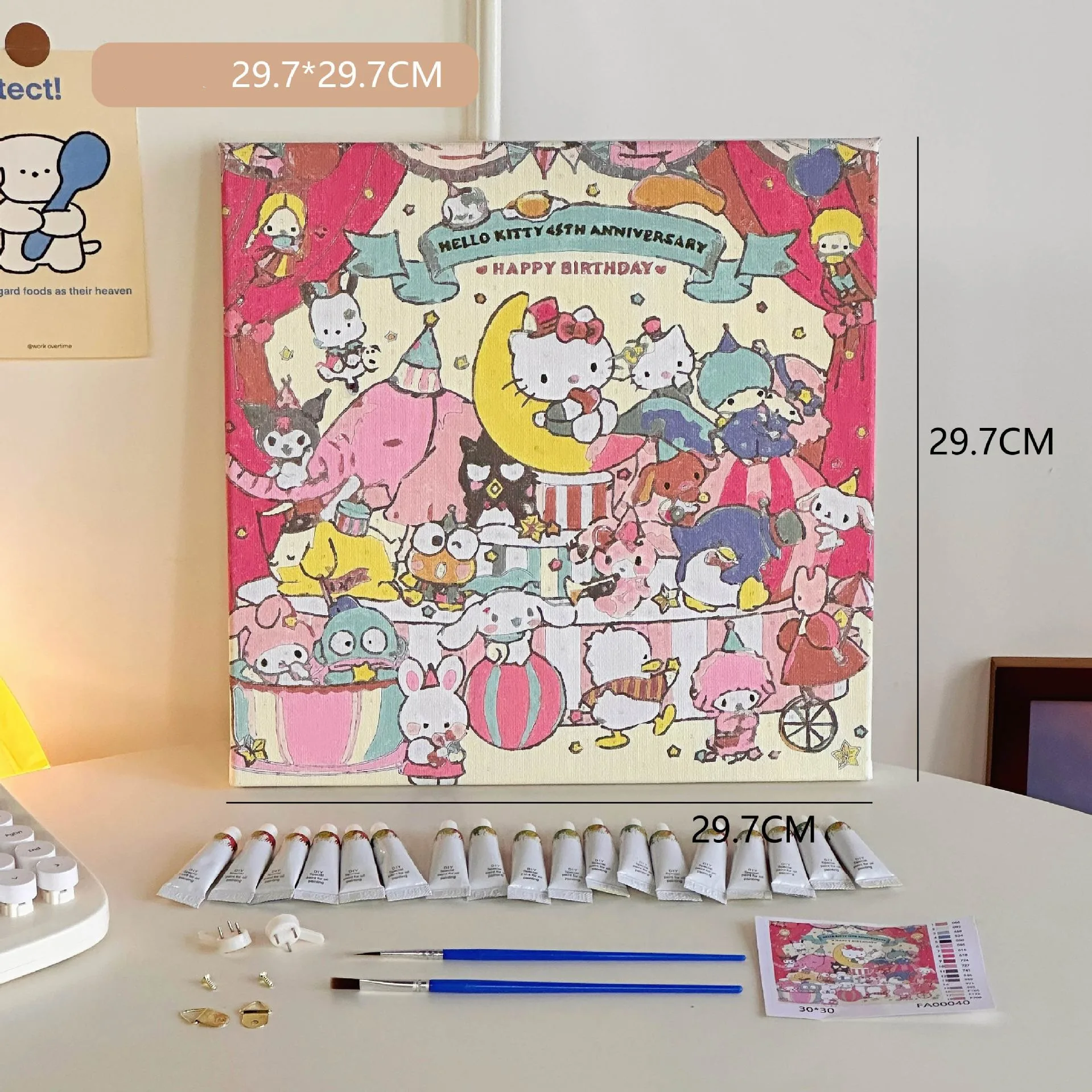 Mini DIY canvas painting kit birthday party design with pre-printed cartoon artwork, acrylic paint tubes, brushes and small accessories laid out on a desk ready for painting