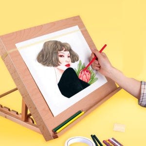 Folding wooden drawing board set at upright angle for illustration work