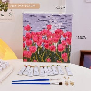 Mini DIY canvas painting kit with pink tulips by rippling water design on a pre-printed canvas, including acrylic paint tubes and brushes arranged on a desk ready for painting