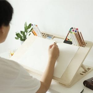 Adjustable drawing board tilted at illustration angle on desk