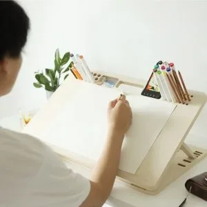 Adjustable drawing board tilted at illustration angle on desk