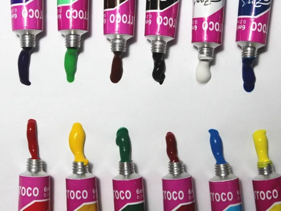 Acrylic paint set with brush showing multiple colour tubes arranged in rows with paint samples
