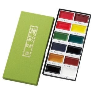 watercolour paint set with twelve assorted colours arranged in a rectangular tray alongside a green presentation box