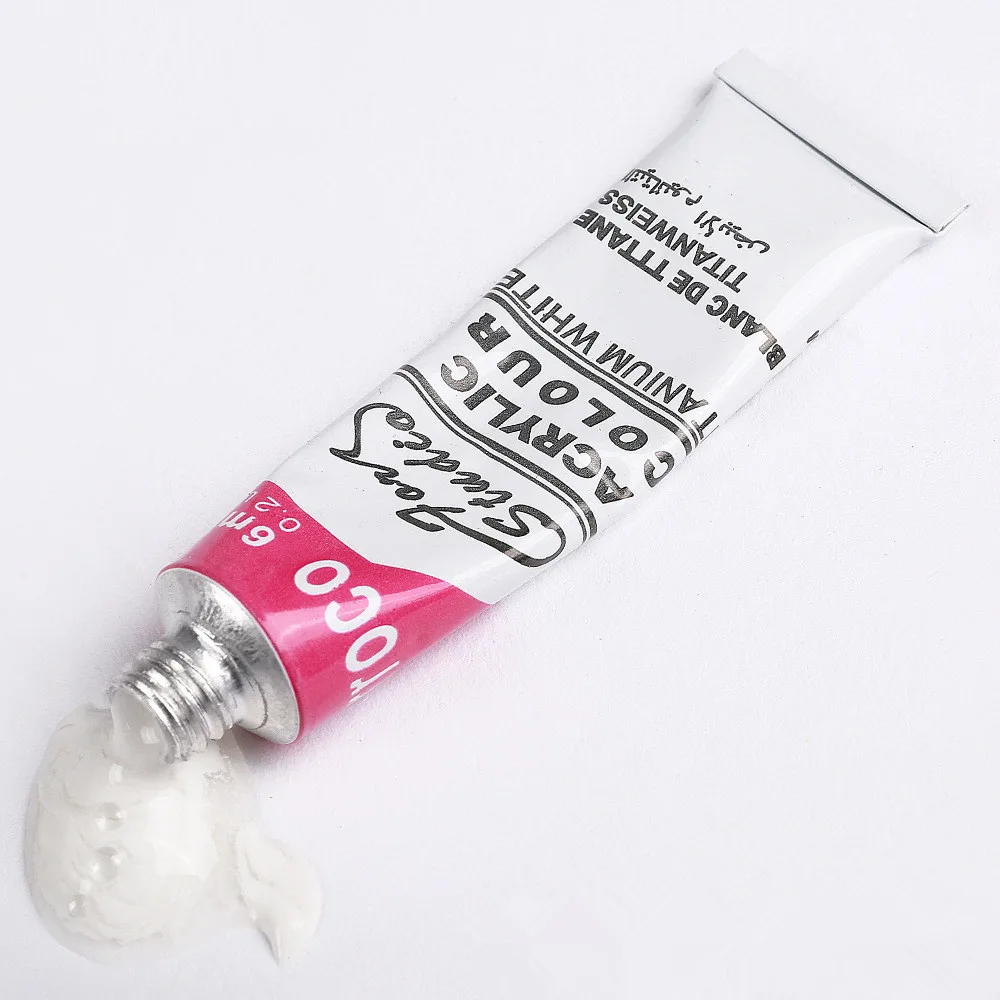 White acrylic paint tube from acrylic paint set with brush with thick paint squeezed out