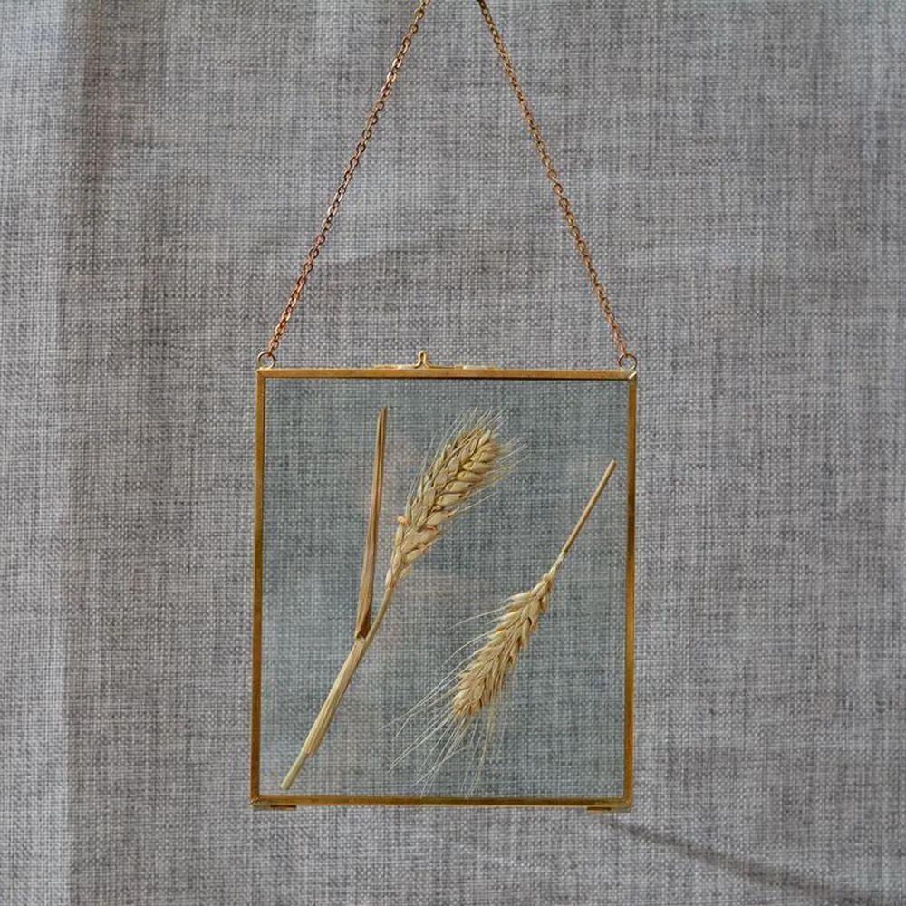 Close-up of welded brass edging on double-sided glass floating frame