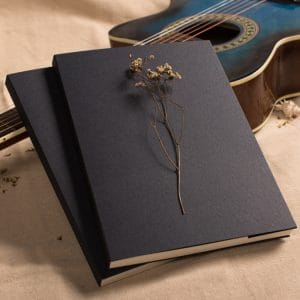 A5 sketchbook with matte black cover and thread bound spine on white background