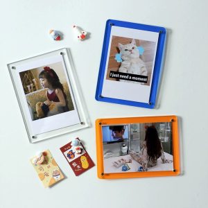 Magnetic acrylic photo frame displaying print on desk in modern interior