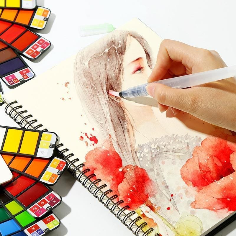 Artist using travel watercolour paint set to sketch a portrait