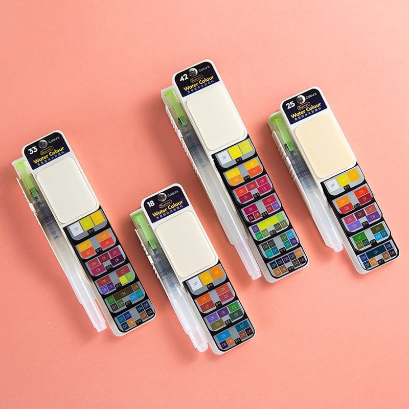 Three travel watercolour paint sets in different sizes on pink background